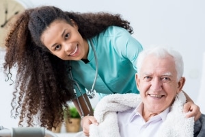 Smiling female caregiver with elderly man