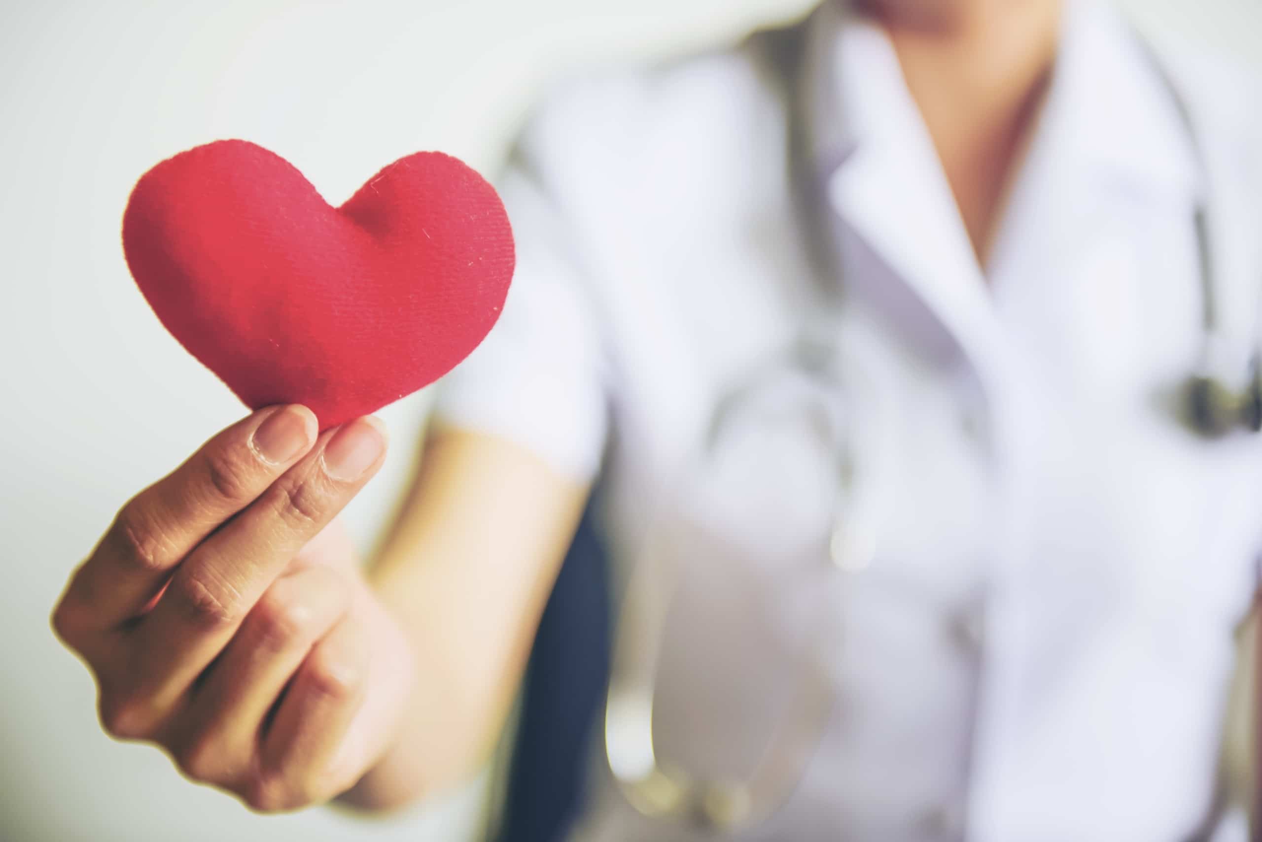Nurse holding a red heart plush