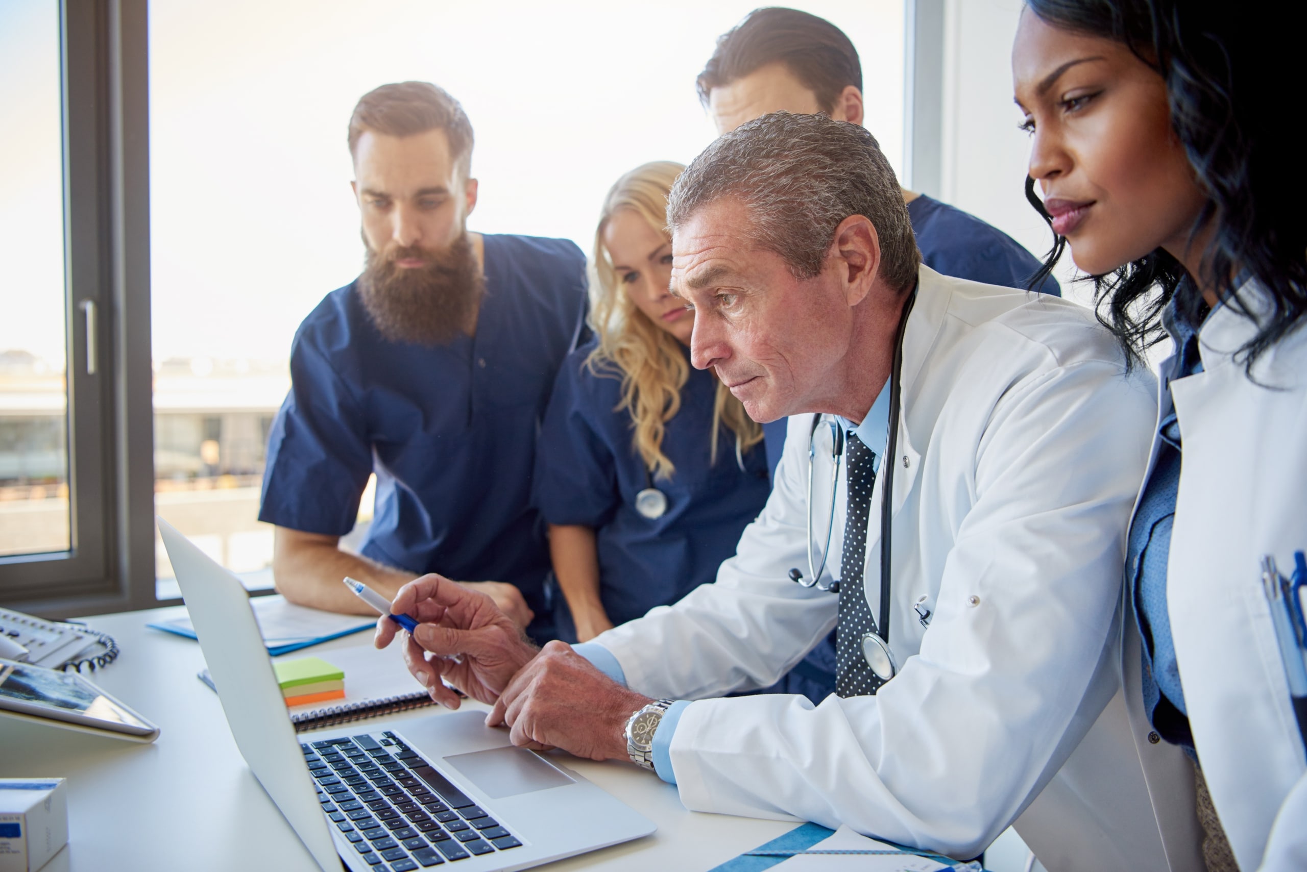 Group of medical workers around a laptop